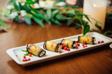 Baked snacks for the holiday, catering. Various light  healthy snacks. Vegetarian appetizer catering grilled zucchini rolls with mozzarella, herbs and tomatoes. Celebration of important event