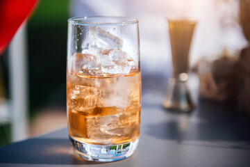 Orange color cocktail with ice in a clear glass close-up, cocktail bar outdoor party, cocktail creation aperol spritz