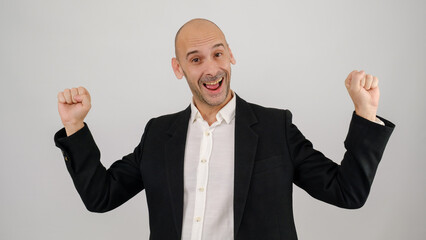 In a studio setting, a middle-aged businessman wearing a suit is standing in front of a white background, celebrating and looking at the camera