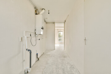 Minimalistic hallway featuring smooth white walls and natural light streaming in, creating a spacious and airy atmosphere.