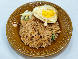 Fried rice, vegetables, crackers with fried egg as a side dish. Fried rice on a glass plate.