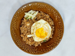 Lalapan Telur.  Rice with fresh vegetables, with traditional Indonesian chili sauce, with fried egg side dish, white background.