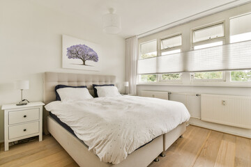 A serene and modern bedroom featuring neutral tones, natural light, and stylish furniture that creates a calm atmosphere perfect for relaxation.