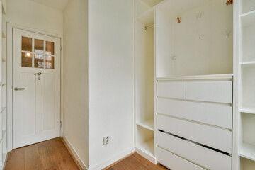 A bright and spacious interior showcases minimalist design with white shelving and wooden flooring, perfect for organizing and creating a serene atmosphere.