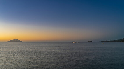 A serene evening after sunset. Pastel shades. The motorboat and the bangka boat are anchored in the...