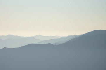 Obraz premium serene sunrise landscape with layers of misty mountains