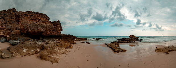 Deserted beach in Oman on an overcast day - panorama