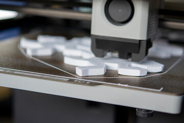 Process of printing on 3D printer. 3D printer creating model from molten plastic close-up. Molten plastic flowing of extruder and forming three-dimensional object white color. Additive technologies