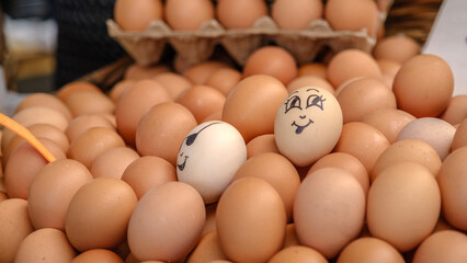 Eggs with faces drawn on them with a bazaar, displayed on a market stall