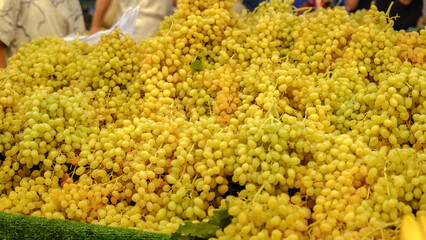 A bazaar stall filled with an abundance of  green grapes