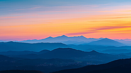 Obraz premium The mountains are covered in blue and the sky is orange