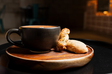 Cup of mocha coffee with pastries on wooden tray in cafeteria