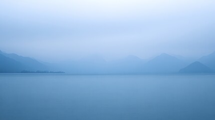 Blue serene lake with mountains in soft focus background