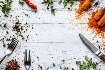 Rustic kitchen scene featuring spices, herbs, and cutlery arranged on a distressed white wooden surface, ideal for culinary-themed designs or food blog backgrounds