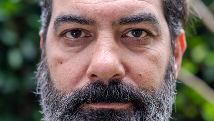 A headshot of a middle-aged man looking seriously at the camera