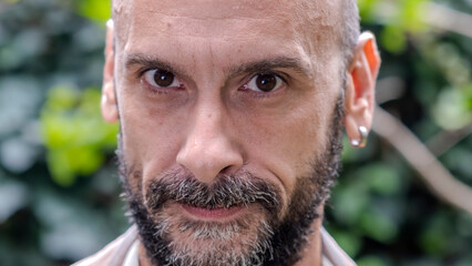 An extreme close-up headshot of a middle-aged man making funny facial expressions while looking at the camera