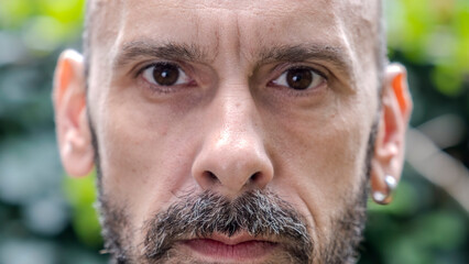 A headshot of a middle-aged man looking seriously at the camera