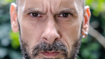 A headshot of a middle-aged man looking seriously at the camera