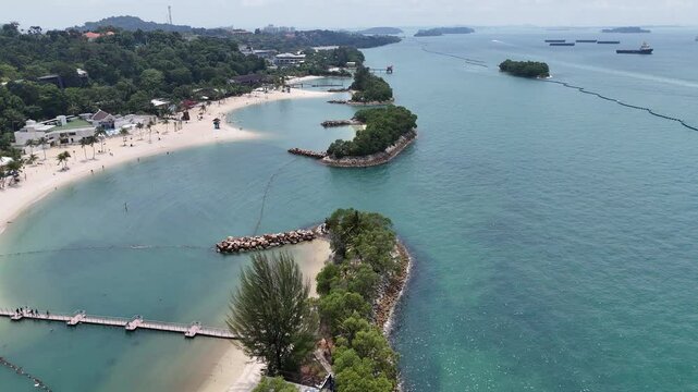Flight over Siloso beach with palm trees at Sentosa Island in Singapore
