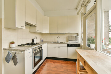A contemporary kitchen showcasing sleek cabinets, modern appliances, and natural light pouring in from large windows, creating a warm and inviting atmosphere.
