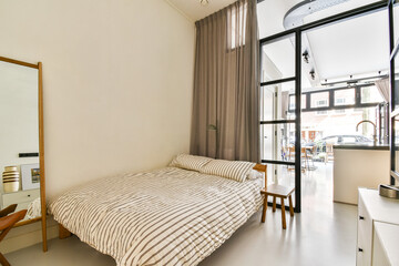 A stylish bedroom featuring elegant furnishings, large windows, and natural lighting, creating a warm and inviting atmosphere for relaxation.