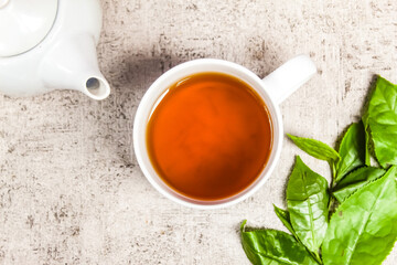 a cup of warm tea with tea leaves on the table