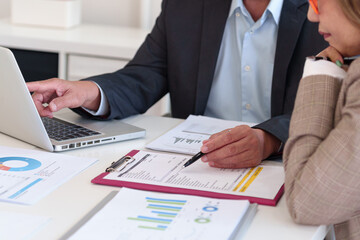Experienced executives analyzing financial data, reviewing company performance, and making...