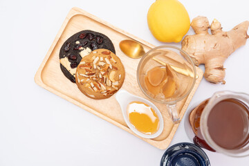 Hot ginger tea with honey and lemon, served with almond cookies, dark cookies, afternoon tea
