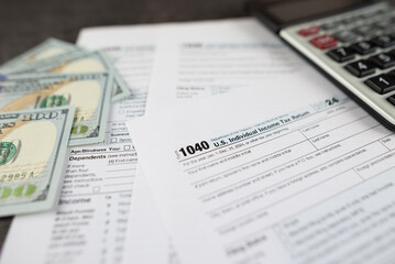 Obraz premium Tax form 1040 on dark wooden background, financial document.