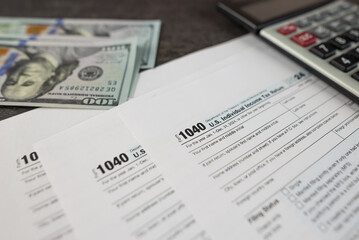 Obraz premium Tax form 1040 on dark wooden background, financial document.