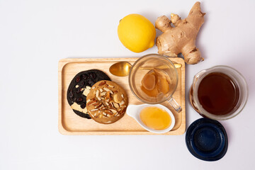 Hot ginger tea with honey and lemon, served with almond cookies, dark cookies, afternoon tea