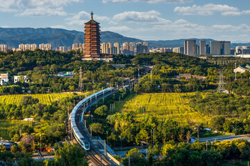 The beauty of the integration of nature and the city where the high-speed rail passes under the Yongding Tower in Beijing, China