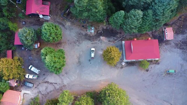Drone footage of cabins and cars in the forest in La Joya at The nevado de colima national park