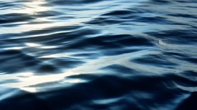 close-up of deep blue ocean water surface with gentle waves and sunlight reflections, abstract nature background with rippling sea texture in high resolution