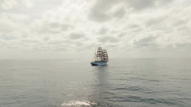 Sea cloud luxury cruise ship sailing vessel in the Atlantic Ocean under cloudy sky, Aerial pullback shot