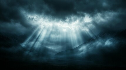 Fototapeta premium Dramatic dark moody landscape with light rays piercing through clouds over misty mountains.