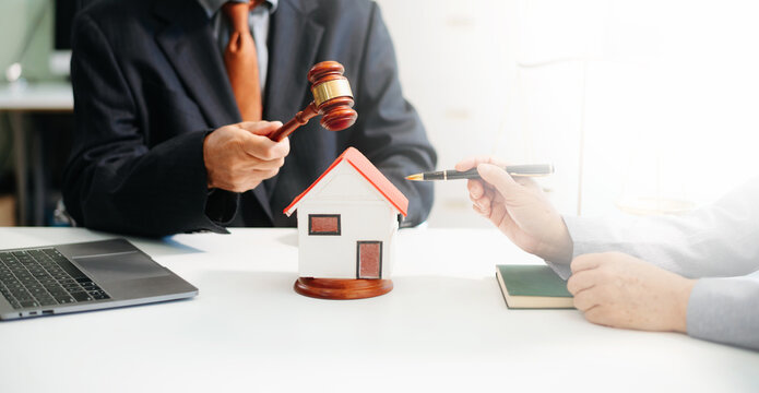 Lawyer handling house foreclosure law with gavel and home model. Legal decision, bankruptcy, and property rights concept.