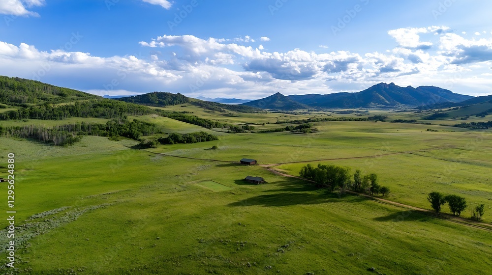 Poster aerial view of expansive green fields and rustic structures set against a backdrop of mountains : ge