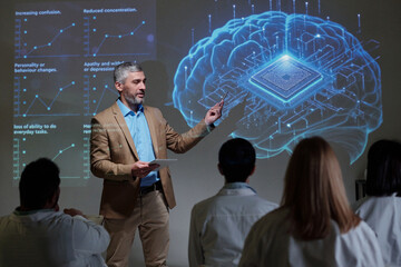 Side view portrait of senior man giving presentation on microchip brain implants pointing at virtual data projections futuristic advanced neurology copy space