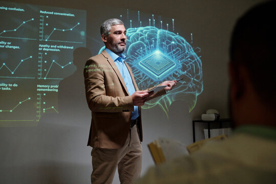 Portrait of mature male neurologist speaking on future of medicine giving presentation on brain implants during medical conference copy space