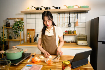 Smiling woman in an apron preparing ingredients for spaghetti in a cozy kitchen