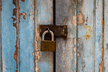 Metal Padlock on old weathering Blue Wooden Door. Close Safety.