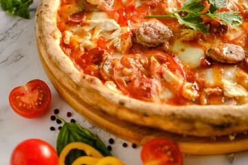 Appetizing, fresh pizza is on the table. Food from an Italian restaurant. Cooking pizza. Pizza ingredients.