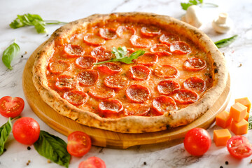 Appetizing, fresh pizza is on the table. Food from an Italian restaurant. Cooking pizza. Pizza ingredients.