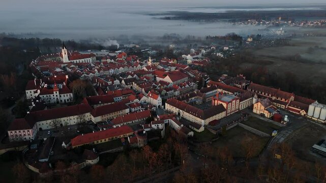 Historical town with fog in the background. Shortly after sunset. Drone.