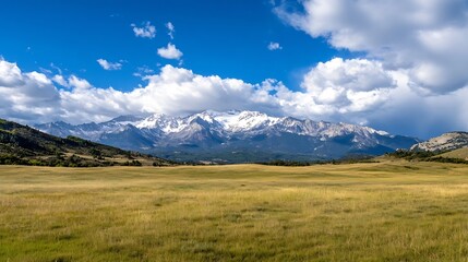 Scenic landscape of snow capped mountains under a bright blue sky with white clouds in the distance : Generative AI