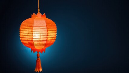 Fototapeta premium a vibrant orange lantern glowing against a deep blue background