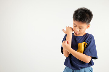 Asian little kid boy scratching itchy arm from a mosquito bite at studio shot isolated on white...