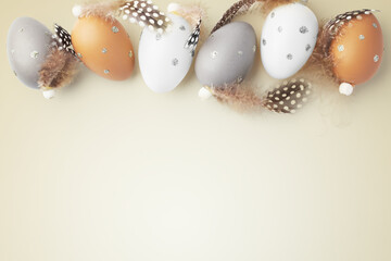 Easter eggs with feathers decor on gold background, easter holiday concept