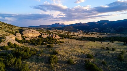 Fototapeta premium Breathtaking View of Rocky Mountains and Rolling Hills Under Cloudy Sky During Sunset : Generative AI